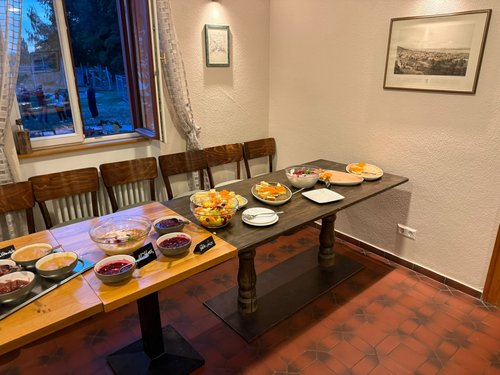 Gedeckter Frühstücks- und Dessertbuffet-Tisch mit Obstsalat, Käsekuchen und Marmeladen in einem Raum des Hofguts.